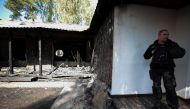 Security guards stand next to the burnt country home of former Central Bank chief Valeria Gontareva in a village north of Kiev, on September 17, 2019. AFP
 