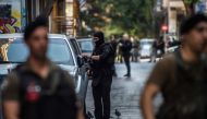 (FILES) In this file photo taken on August 26, 2019 Police officers stand guard outside a building during an evacuation operation, in the Exarchia district, central Athens. AFP / ANGELOS TZORTZINIS