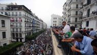 People watch demonstrators shouting slogans during a protest to reject the Algerian election announcement for December, in Algiers, Algeria September 20, 2019. Reuters/Ramzi Boudina
 