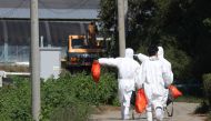 Quarantine officials wearing protective gear walk near a pig farm involved in African swine fever in Yeoncheon, South Korea, September 18, 2019. Yonhap via REUTERS