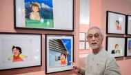Japanese animator and character designer Yoichi Kotabe poses next to cartoon boards from the Japanese animated series 