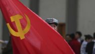 A participant waves a Chinese Communist Party flag as he waits backstage before his performance at a line dancing competition in Kunming Yunnan province, January 31, 2015. Reuters