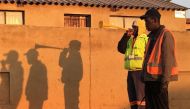 The shadows of Isaac Makhubo and Paul Themba blowing vuvuzela trumpets silhouette against a wall in in Johannesburg, South Africa on 19 September, 2019. Thomson Reuters Foundation/Kim Harrisberg