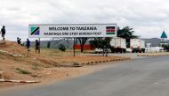 Children walk past a signage at the border crossing point between Kenya and Tanzania in Namanga, Tanzania July 19, 2019. Picture taken July 19, 2019. REUTERS/Njeri Mwangi