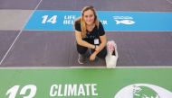 South African climate activist Zoe Prinsloo poses in front of a floor mural showing Sustainable Development Goal number 13, 