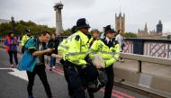 Police officers detain an activist at Lambeth Bridge during the Extinction Rebellion protest in London, Britain October 7, 2019. REUTERS/Henry Nicholls