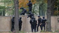 Policemen climb over a wall close to the site of a shooting in Halle an der Saale, eastern Germany, on October 9, 2019. Germany OUT / AFP / dpa / Sebastian Willnow