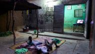 Two displaced children lie down to watch the television in the court of a house in Segou on September 30, 2019.  AFP / Michele Cattani 
