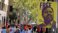 FILE PHOTO: People walk past a banner depicting dismissed Catalan Vice President Oriol Junqueras, currently in custody awaiting trial on charges of sedition, rebellion and misappropriation of public funds, during Catalonia's national day 'La Diada' in Bar