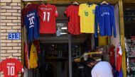 Kosovo Albanian pedestrian walking past a replica football jersey of Switzerland midfielder Granit Xhaka outside a shop in the Kosovo capital Pristina on June 18, 2018. AFP / Armend Nimani