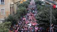 Demonstrators carry national flags and banners during an anti-government protest in downtown Beirut, Lebanon October 20, 2019. REUTERS/Ali Hashisho