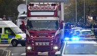 Police officers drive away a lorry (C) in which 39 dead bodies were discovered sparking a murder investigation at Waterglade Industrial Park in Grays, east of London, on October 23, 2019. (AFP / Ben STANSALL)