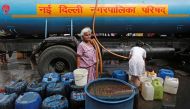 A woman stands after filling her containers with drinking water from a municipal tanker in New Delhi, India, June 28, 2019. Reuters / Adnan Abidi