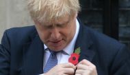 Britain's Prime Minister Boris Johnson pins a poppy to his lapel on the steps of 10 Downing street as he meets with fundraisers for the Royal British Legion in central London on October 28, 2019. AFP / ISABEL INFANTES