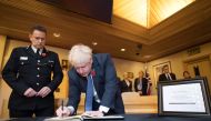 Britain's Prime Minister Boris Johnson signs a book of condolence during a visit to Thurrock Council Offices in Thurrock, east of London on October 28, 2019, following the October 23, 2019, discovery of 39 bodies concealed in a lorry.  AFP / Stefan Rousse