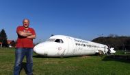 Croatian citizen Robert Sedlar poses in front of a former SunAdria Holland Fokker-100 aircraft in his garden in Strmec Stubicki, near Zagreb, Croatia, on October 26, 2019. AFP / Denis Lovrovic  