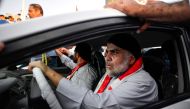 Iraqi Shiite cleric Moqtada al-Sadr (R) drives a car as he joins anti-government demonstrators gathering in the central holy city of Najaf on October 29, 2019.  AFP / Haidar HAMDANI