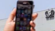 In this file photo taken on August 28, 2016 an Israeli woman uses her iPhone in front of the building housing the Israeli NSO group, in Herzliya, near Tel Aviv.  AFP / Jack Guez
 