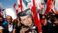 A supporter of Lebanon's President Michel Aoun holds his pictures during a rally in Baabda near Beirut, Lebanon, November 3, 2019. REUTERS/Goran Tomasevic
 