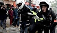 Police officers detain a man during clashes with protesters on November 16, 2019, near Place d'Italie in Paris, on the sidelines of a demonstration of the 