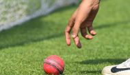 A cricketer picks up a pink ball during Bangladesh's practice session at The Eden Gardens cricket stadium in Kolkata on November 20, 2019, ahead of the second Test cricket match between India and Bangladesh. / AFP / Dibyangshu SARKAR 