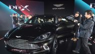 Journalists and guests look at the Aston Martin DBX SUV at its world premiere in Beijing on November 20, 2019. Aston Martin launched its first ever SUV in the Chinese capital on November 20. / AFP / GREG BAKER