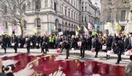 Members of the Extinction Rebellion pour artificial blood during a climate protest outside 10 Downing Street in London, March 9, 2019. Credit:  Extinction Rebellion