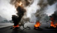 FILE PHOTO: Smoke rises from tyres set ablaze by anti-government rioters on a main road near a government building in Beirut May 7, 2008. REUTERS/Jamal Saidi/File Photo