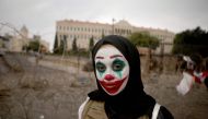 A Lebanese woman with her face painted with the character of the Joker takes part in a protest in downtown Beirut on October 23, 2019. AFP / Patrick Baz