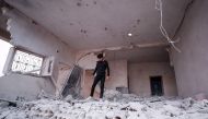 A Syrian youth walks through rubble and debris in a building that was damaged by a reported government forces' air strike in the village of al-Haraki in the northwestern Idlib province on December 1, 2019. / AFP / Omar Haj Kadour 