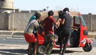 Iraqi men carry a wounded protester into a Tuk-Tuk during a demonstration against state corruption failing public services and unemployment in central Khellani Square, Baghdad on October 4, 2019. AFP / Ahmad Al-Rubaye