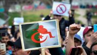 A file photo taken on March 03, 2019 shows protesters holding placards during a sit-in against the then Algerian president’s bid for a fifth term in office at the Porte d Aix in Marseille. AFP / Gerard Julien