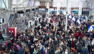Travelers wait to board their train as Gare de Lyon railway station in Paris on December 20, 2019, on the 16th day of a nationwide multi-sector strike against the government's pensions overhaul. / AFP / Martin Bureau

