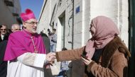 Apostolic Administrator of the Latin Patriarchate of Jerusalem Pierbattista Pizzaballa (L) is greeted by a Palestinian woman upon his arrival to the biblical West Bank city of Bethlehem on December 24, 2019. AFP / Hazem Bader 