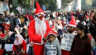 A man wearing a Santa Claus costume gives hats to kids during a protest against a new citizenship law, outside the Jamia Millia Islamia university in New Delhi, India, December 25, 2019. Reuters/Adnan Abidi