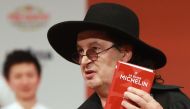 French chef Marc Veyrat, holds a Michelin guide after being awarded the maximum three Michelin stars, during the Michelin guide award ceremony at La Seine Musicale in Boulogne-Billancourt near Paris, on February 05, 2018. AFP / Jacques Demarthon
 
 