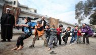 Syrian children displaced from Maaret Al-Numan play in the yard of a former jail turned into a makeshift refugee shelter in the northwestern city of Idlib on December 31, 2019, during activities organised by a local aid association.  AFP / Omar Haj Kadour