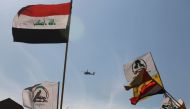 An Apache military helicopter flies over the US embassy as supporters of Iraq's Hashed al-Shaabi paramilitary force protest to condemn the US air strikes that killed Hashed fighters over the weekend, in the Iraqi capital Baghdad on January 1, 2020. AFP /