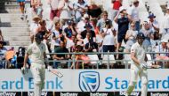 England's Dom Sibley (L) and England's Zak Crawley (R) walks on the field to bat during the first day of the second Test cricket match between South Africa and England at the Newlands stadium in Cape Town on January 3, 2020. (AFP / MARCO LONGARI)