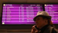 A woman uses a smartphone as she walks past an arrivals board displaying the Ukraine International Airlines Flight PS752 from Tehran marked as canceled at the Boryspil airport outside Kiev on January 8, 2020. AFP / Sergei Supinsky