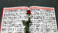A rose rests on a page featuring photographs of people who have died in Iran as Iranian Americans from across California converge in Los Angeles to participate in the California Convention for a Free Iran and to express support for nationwide protests in