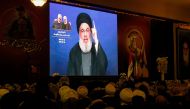Supporters of the the Shiite Hezbollah movement watch as the movement's leader Hasan Nasrallah delivers a speech on a screen in the southern Lebanese city of Nabatieh on January 12, 2020. AFP / Mahmoud Zayyat
