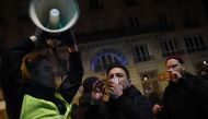A protestor speaks in a megaphone during a demonstration in front of the Bouffes du Nord theatre in Paris on January 17, 2020, as French President attends a play. AFP / Lucas BARIOULET
