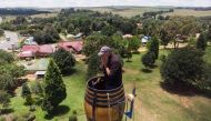 An areal view shows Vernon Kruger, 52, holding his face while standing in a barrel at the top of a pole 25 metres above the ground in Dullstroom on January 16, 2020. AFP / Antoine Demaison 