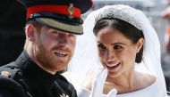 Prince Harry, his wife Meghan, Duchess of Sussex wave from the Ascot Landau Carriage during their wedding procession on the Long Walk, May 19, 2018. AFP pool / Aaron Chown