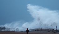 A man walks beside a sea wave during the storm 