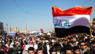 Iraqi demonstrators wave the national flag during an anti-government rally in the southern city of Basra on January 26, 2020. AFP / Hussein FALEH