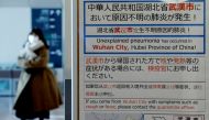 A woman wearing a mask walks past a quarantine notice about the outbreak of coronavirus in Wuhan, China at an arrival hall of Haneda airport in Tokyo, Japan, January 20, 2020. REUTERS/Kim Kyung-Hoon/File Photo 