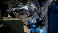 FILE PHOTO: child sits outside a tent at a makeshift camp for refugees and migrants next to the Moria camp on the island of Lesbos, Greece, September 1, 2019. REUTERS/Alkis Konstantinidis