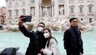 Tourists wearing protective masks take a selfie in front of ther Trevi's Fountain after two cases of coronavirus were confirmed in in the country, in Rome, Italy January 31, 2020. REUTERS/Remo Casilli